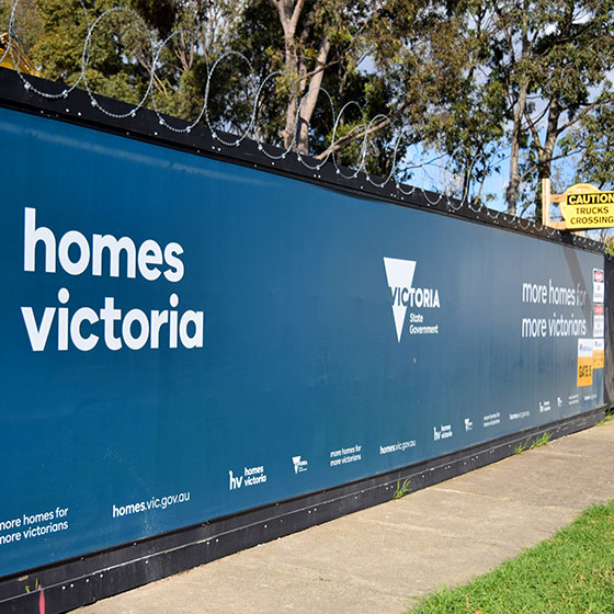 Construction-hoarding-with-printed-vinyl-banners-and-razor-wire-installed-at-a-construction-site-for-homes-Victoria-in-Melbourne